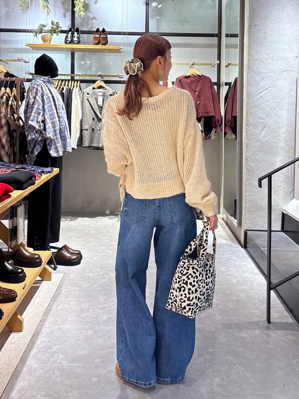 ゴールド系のタンクトップ、その他のショルダーバッグ、ブルー系のデニムパンツを着用したレディースの秋コーディネートの5枚目の写真