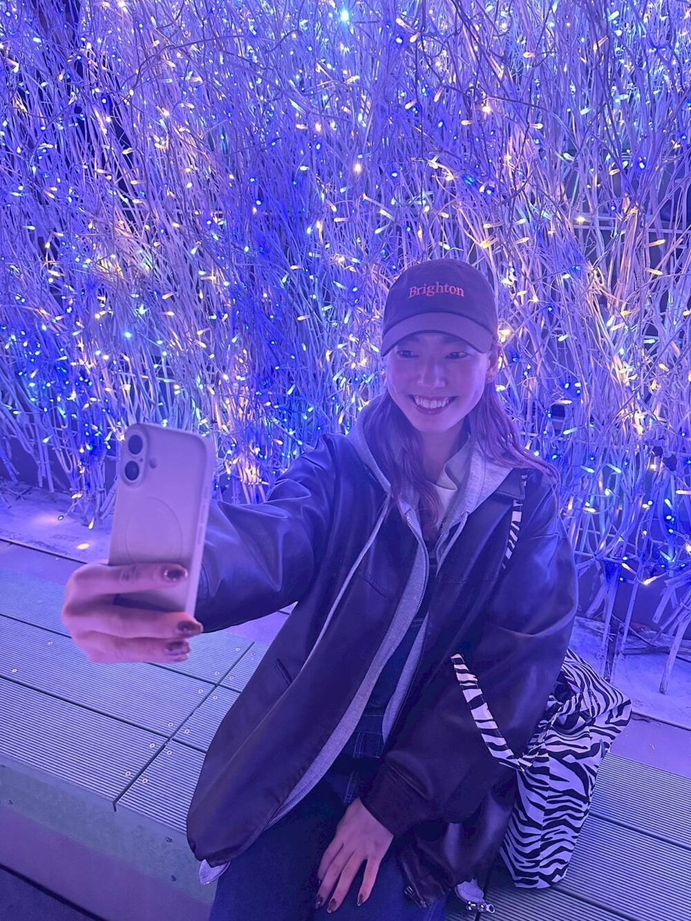 ブラウン系のブルゾン、ブルー系のTシャツ/カットソー、グレー系のパーカーを着用したレディースの秋コーディネートの2枚目の写真