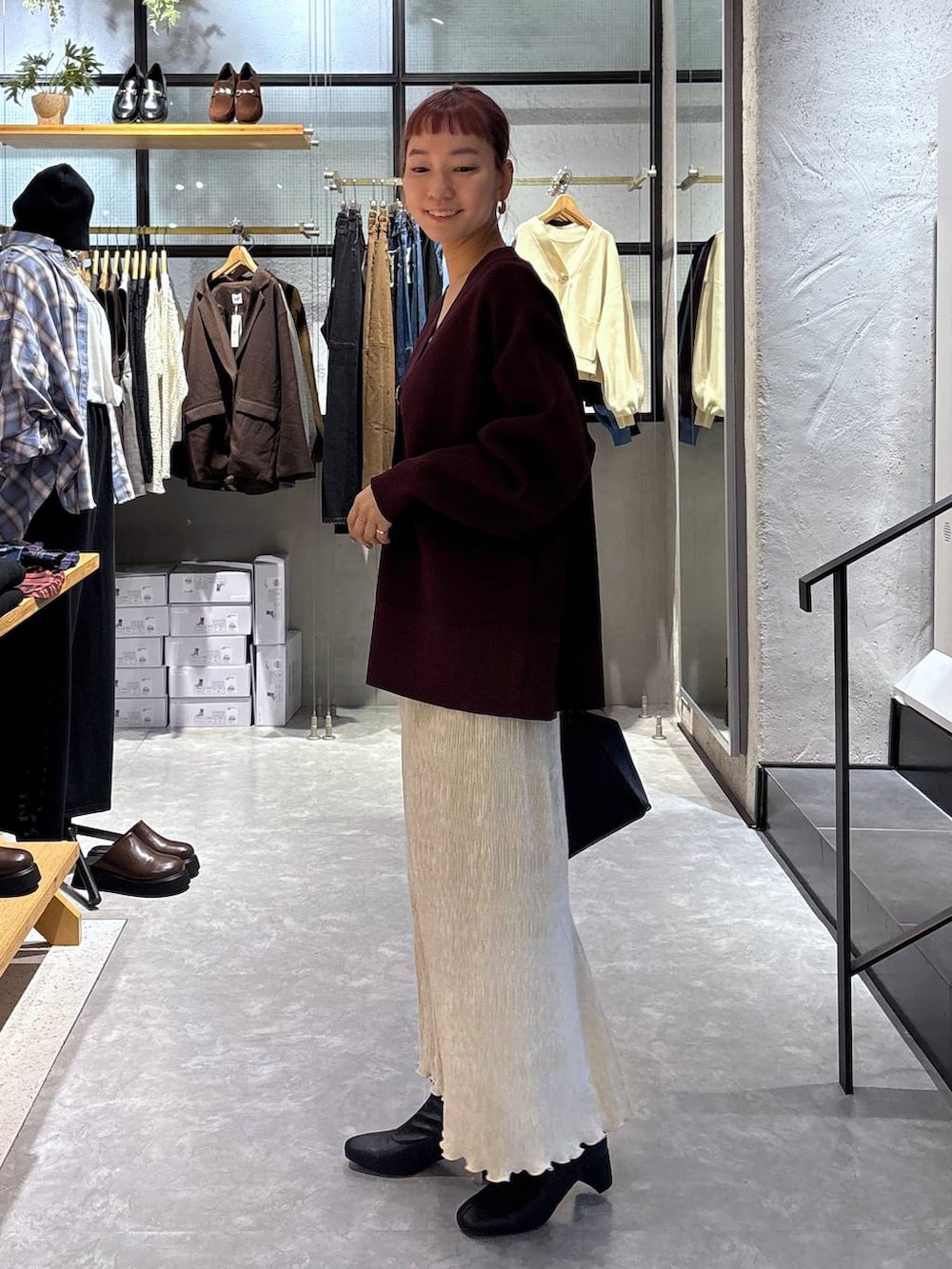 ゴールド系のタンクトップ、ブラック系のショルダーバッグ、レッド系のカーディガン/ボレロを着用したレディースの秋コーディネートの4枚目の写真