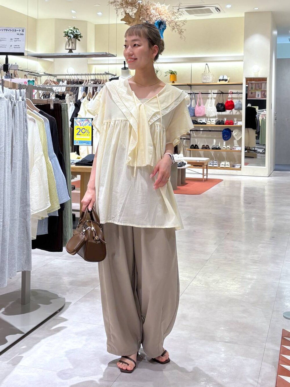 ゴールド系のタンクトップ、ブラウン系のサンダル、ベージュ系のその他パンツを着用したレディースの夏コーディネートの2枚目の写真