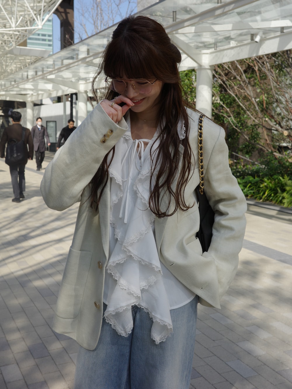 ホワイト系のシャツ/ブラウス、ホワイト系のテーラードジャケット、ブルー系のデニムパンツを着用したレディースの春コーディネートの2枚目の写真