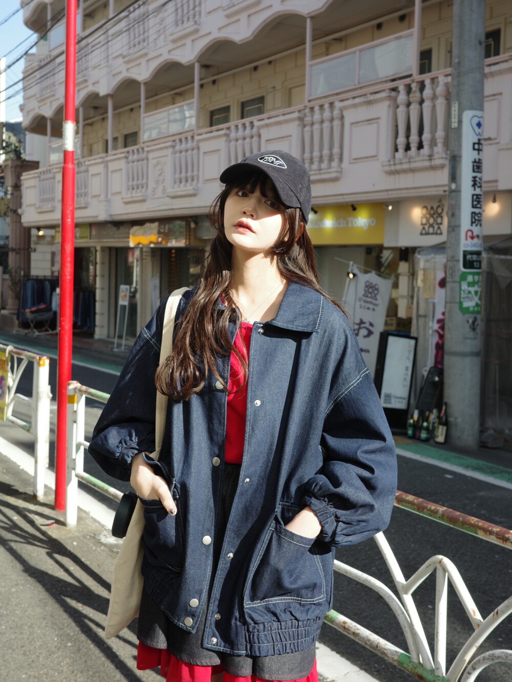 ブルー系のデニムスカート、ブルー系のデニムジャケット、ブラック系のブーツを着用したレディースの冬コーディネートの2枚目の写真
