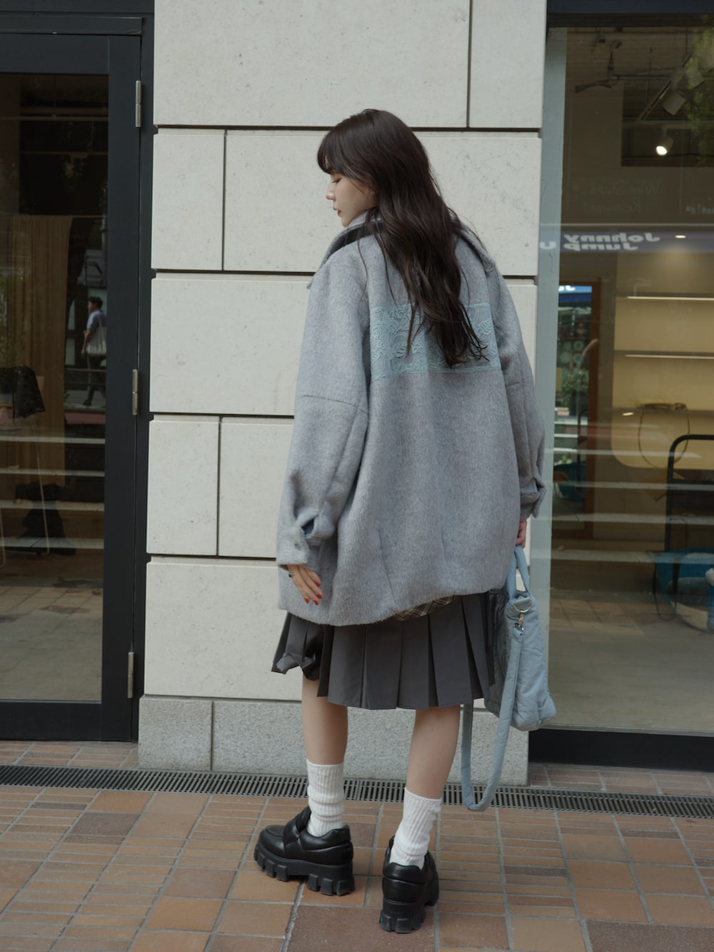 グレー系のその他アウター、ブルー系のショルダーバッグを着用したレディースの秋コーディネートの2枚目の写真