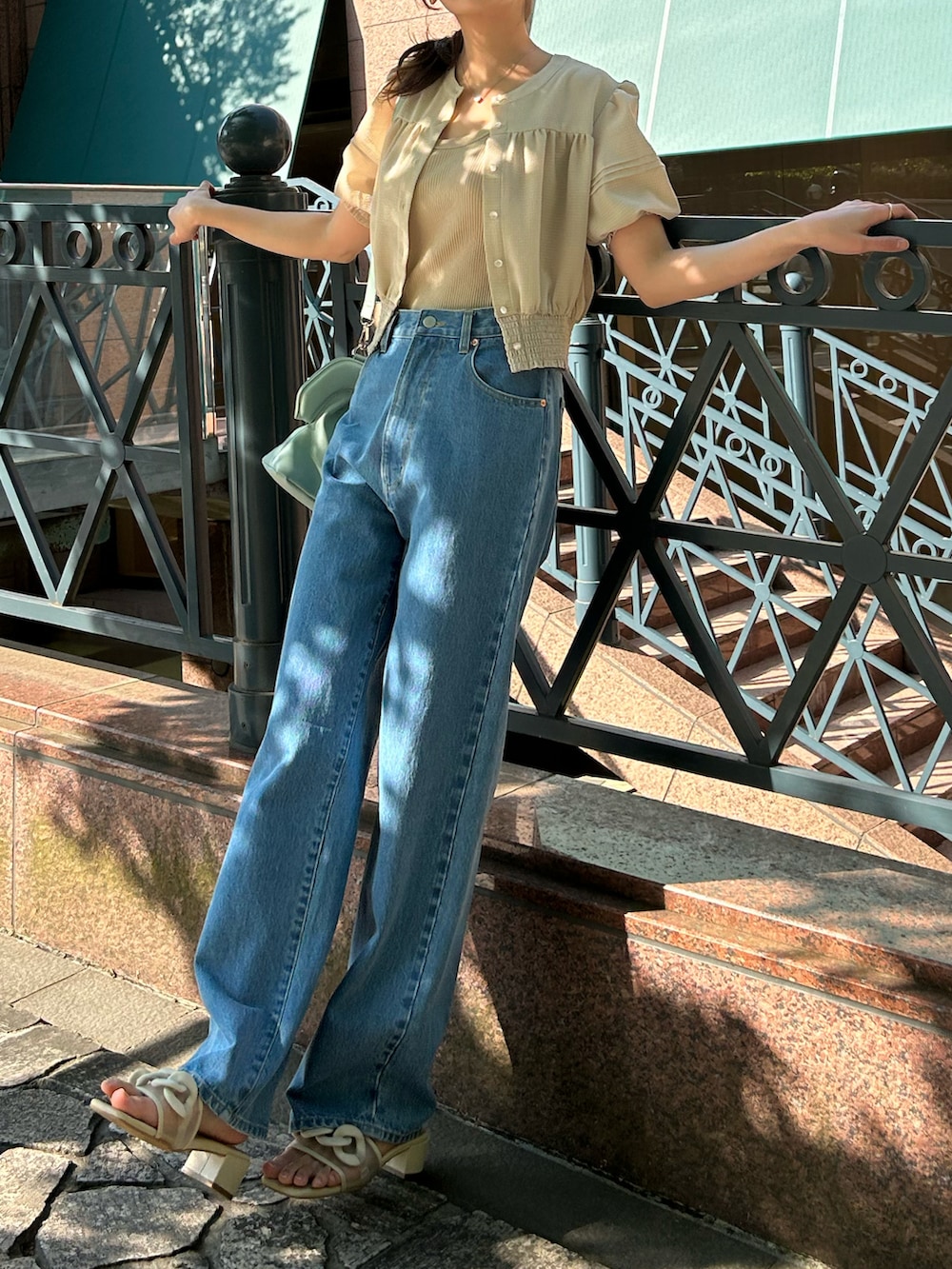 ベージュ系のシャツ/ブラウス、ブルー系のデニムパンツ、ベージュ系のサンダルを着用したレディースの夏コーディネートの2枚目の写真