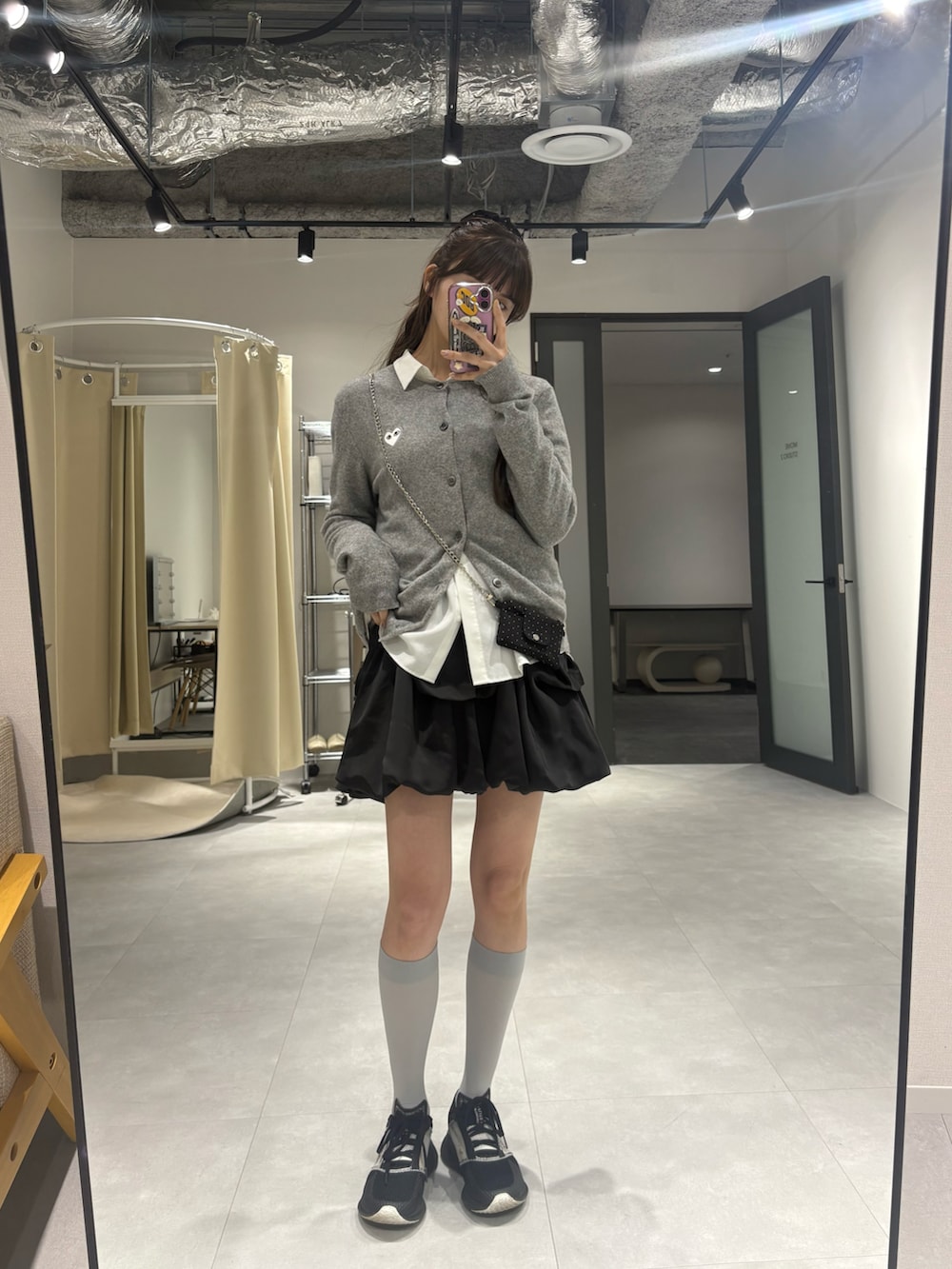 ブラック系のスカート、グレー系のカーディガン/ボレロを着用したレディースの春コーディネートの2枚目の写真