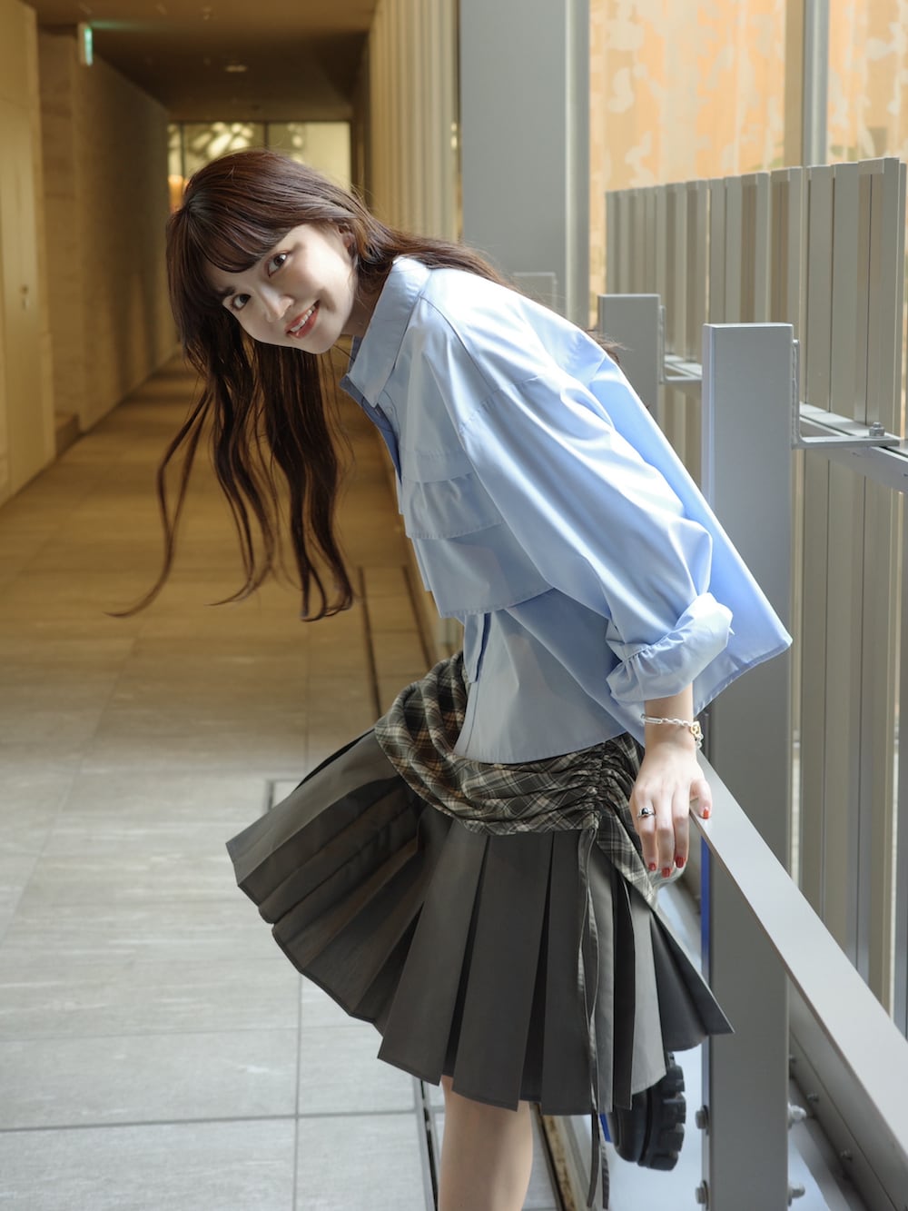 ブルー系のシャツ/ブラウス、ブルー系のショルダーバッグ、グレー系のスカートを着用したレディースの秋コーディネートの2枚目の写真