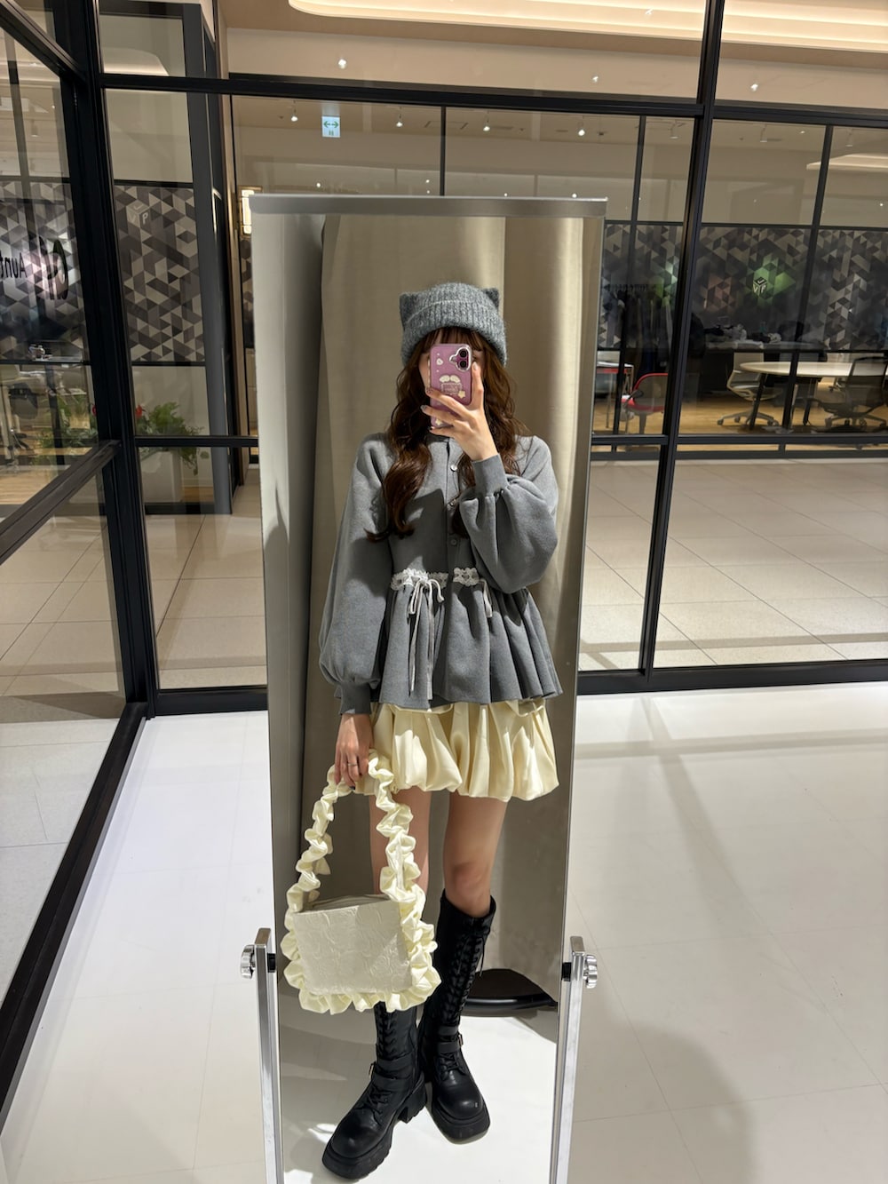 グレー系のカーディガン/ボレロ、ホワイト系のハンドバッグ、グレー系のニットキャップ/ビーニーを着用したレディースの冬コーディネートの3枚目の写真