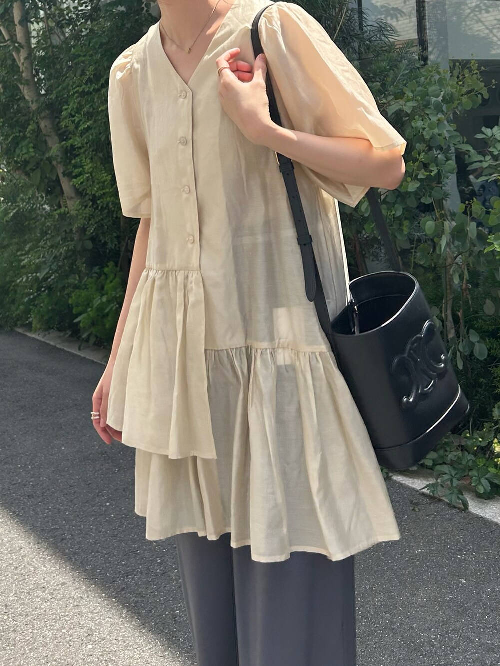 ホワイト系のチュニックを着用したレディースの夏コーディネートの2枚目の写真