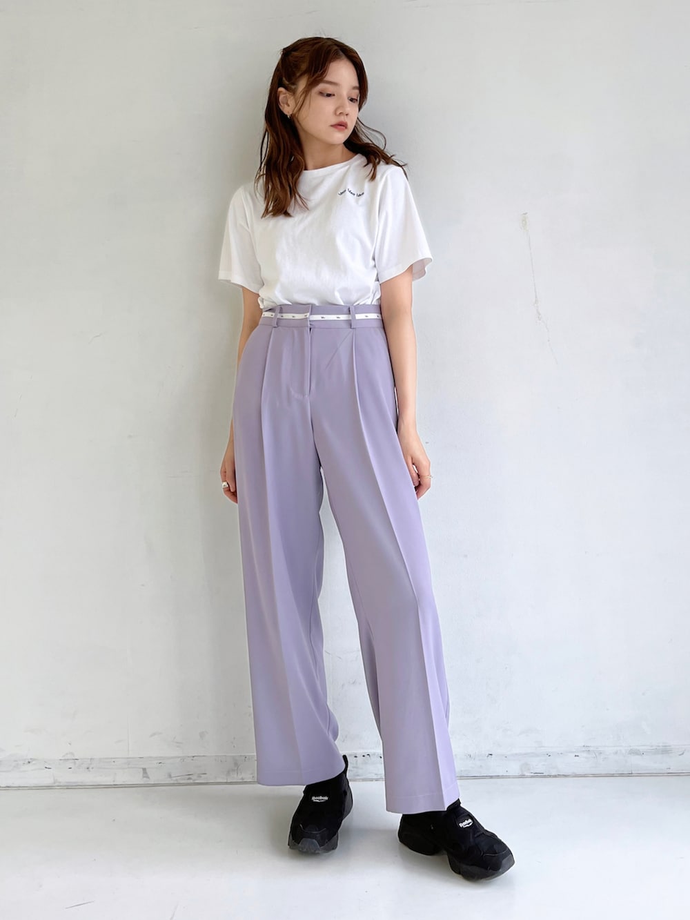 ホワイト系のTシャツ/カットソー、ブラック系のスニーカー、パープル系のスラックスを着用したレディースの春コーディネートの2枚目の写真