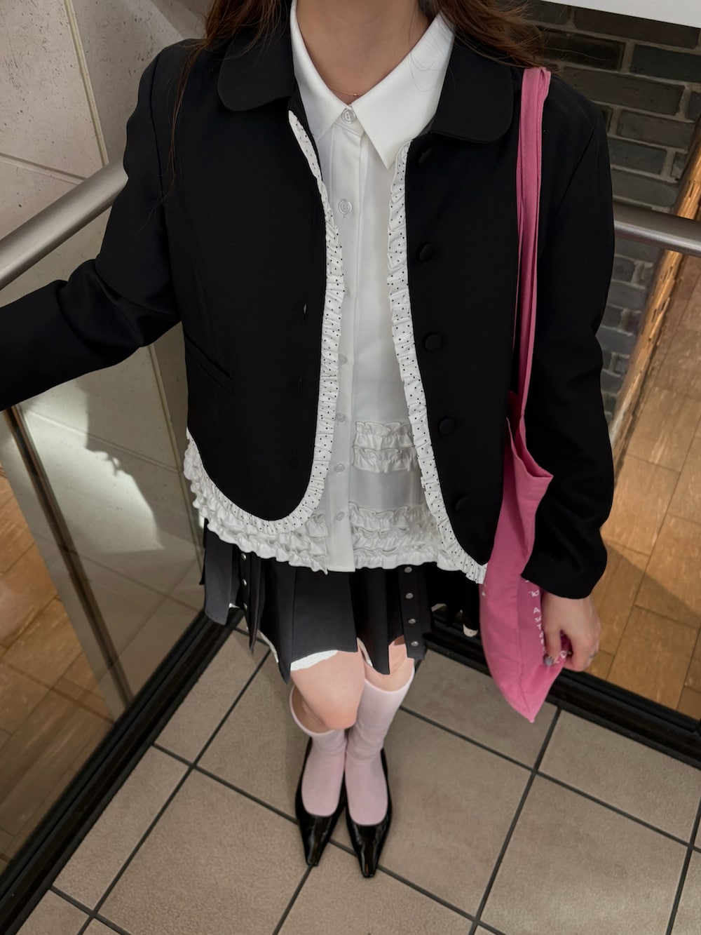 グレー系のスカート、ブラック系のテーラードジャケット、ホワイト系のシャツ/ブラウスを着用したレディースの秋コーディネートの2枚目の写真