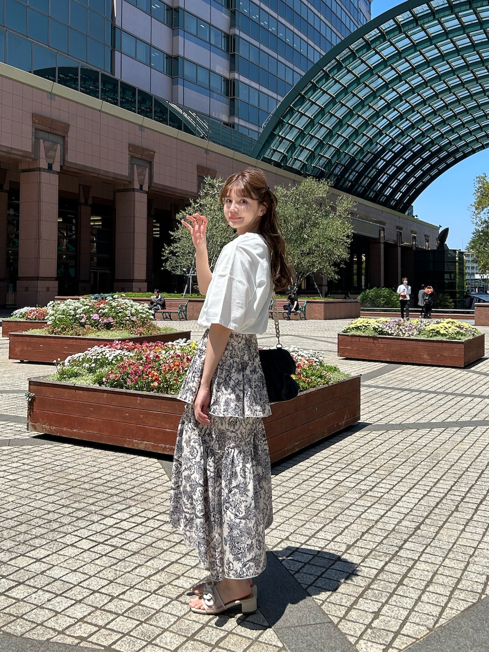 ホワイト系のスカート、ホワイト系のTシャツ/カットソー、ベージュ系のサンダルを着用したレディースの夏コーディネートの2枚目の写真