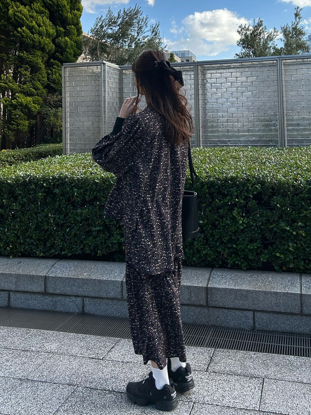 ブラック系のスニーカー、ブラック系のシャツ/ブラウス、ブラック系のスカートを着用したレディースの冬コーディネートの2枚目の写真