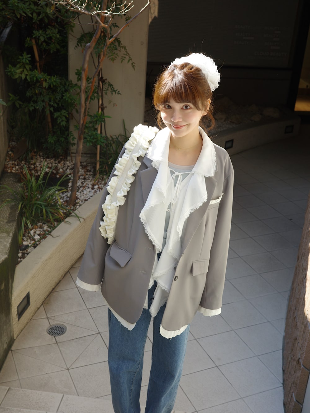 ホワイト系のシャツ/ブラウス、グレー系のテーラードジャケット、ブルー系のデニムパンツを着用したレディースの春コーディネートの4枚目の写真