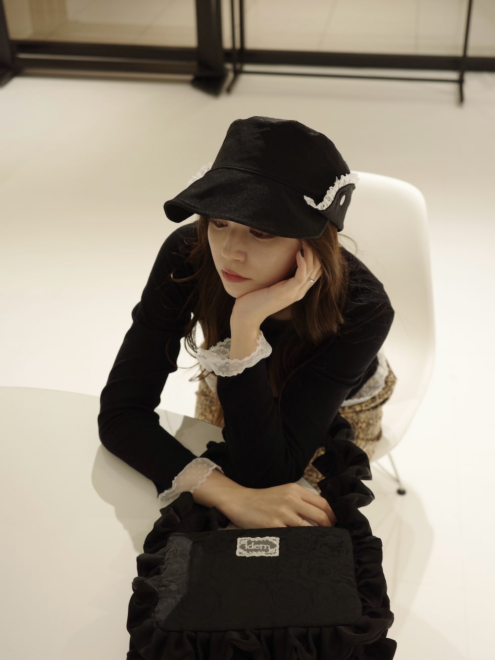 ブラック系のハンドバッグ、ブラック系のキャスケットを着用したレディースの秋コーディネートの2枚目の写真