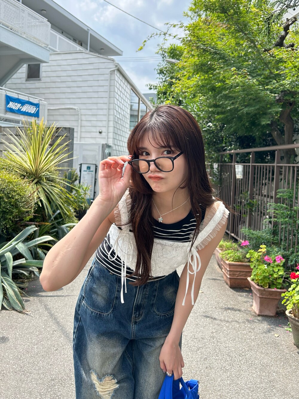 ホワイト系のベスト、ゴールド系のネックレスを着用したレディースの夏コーディネートの2枚目の写真