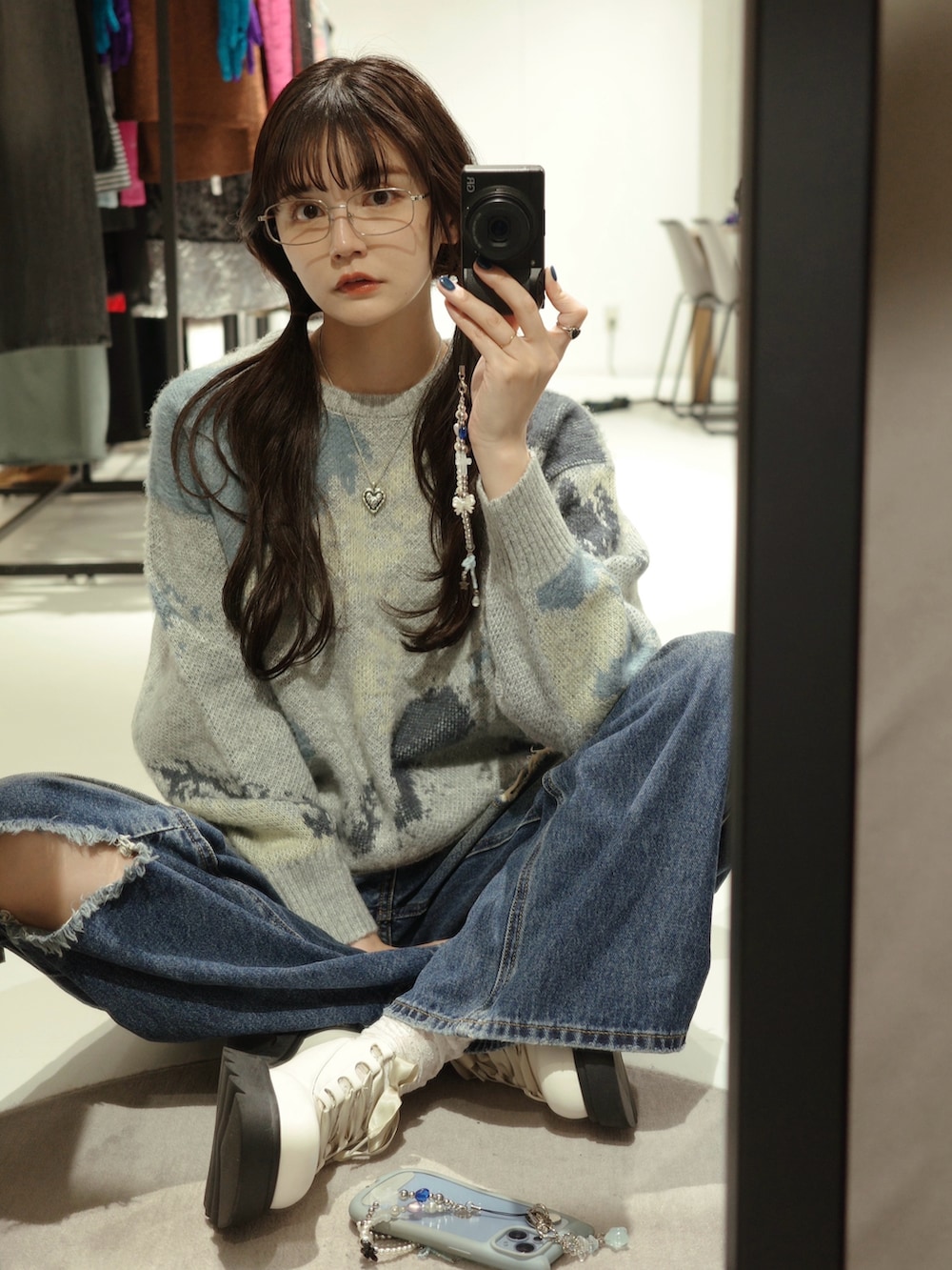 グレー系のニット/セーター、ブルー系のデニムパンツ、ホワイト系のショルダーバッグを着用したレディースの秋コーディネートの4枚目の写真