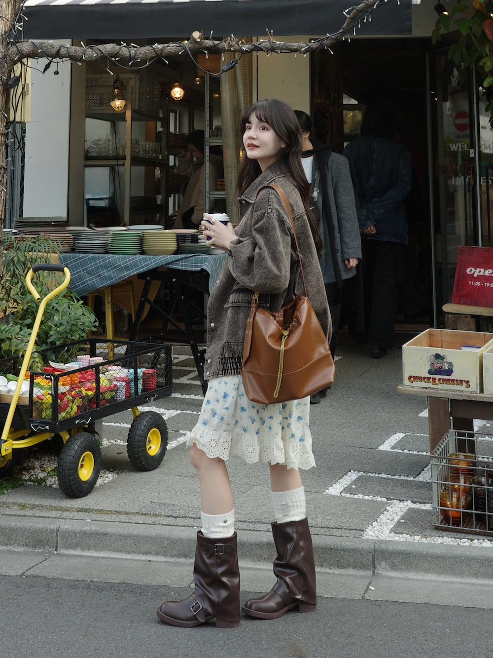 ブラウン系のデニムジャケット、ブラウン系のショルダーバッグ、ホワイト系のワンピースを着用したレディースの冬コーディネートの2枚目の写真