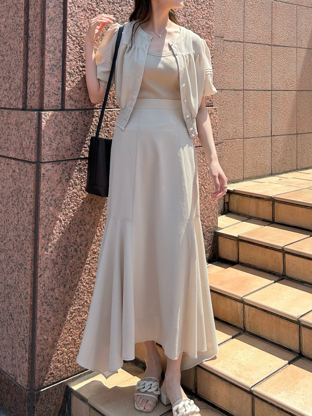 ベージュ系のシャツ/ブラウス、ベージュ系のスカート、ベージュ系のサンダルを着用したレディースの夏コーディネートの3枚目の写真