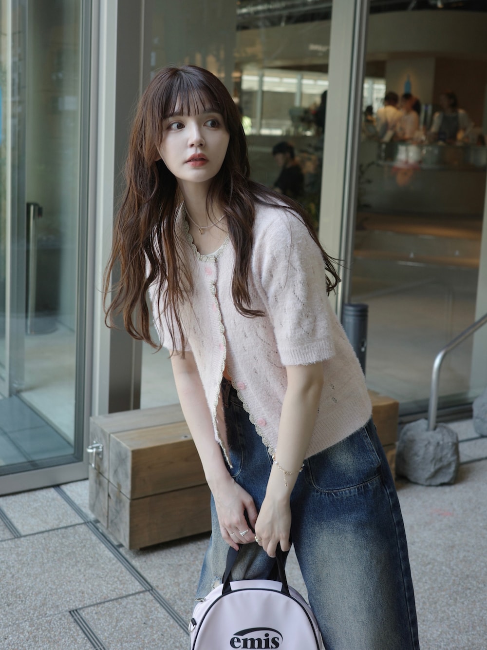 ブルー系のデニムパンツ、ピンク系のカーディガン/ボレロ、ピンク系のネックレスを着用したレディースの夏コーディネートの2枚目の写真