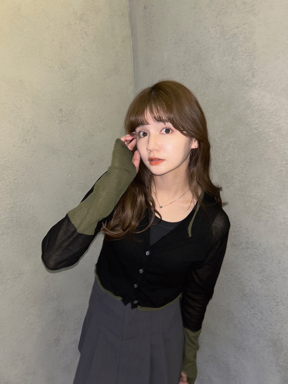 ブラック系のカーディガン/ボレロ、ブラック系のローファー、グレー系のスカートを着用したレディースの春コーディネートの3枚目の写真