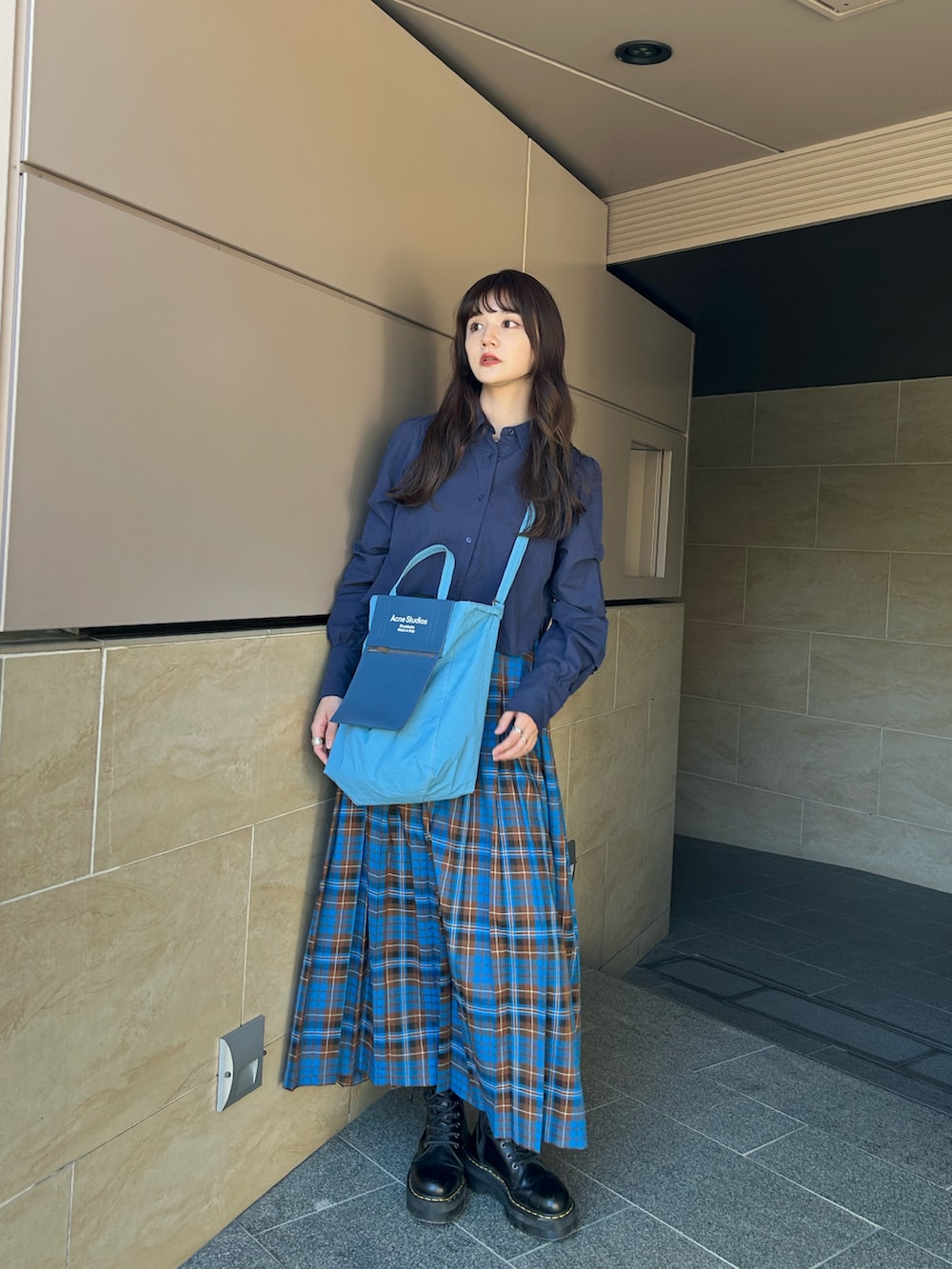 ブルー系のシャツ/ブラウス、ブラック系のブーツ、ブルー系のバッグを着用したレディースの秋コーディネートの2枚目の写真