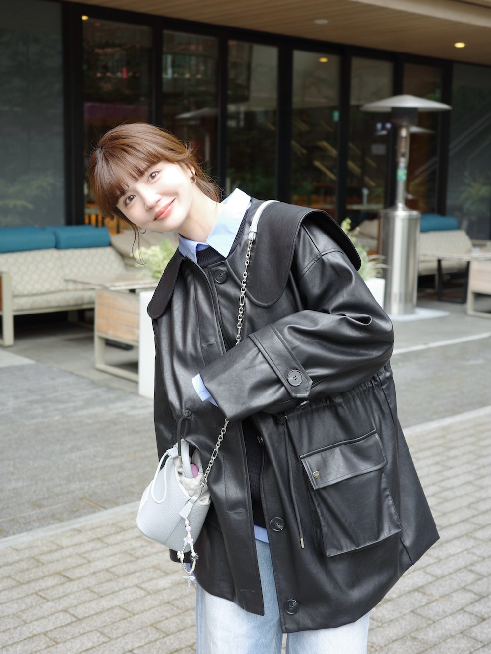 ブラック系のノーカラージャケット、ブルー系のデニムパンツ、ブルー系のシャツ/ブラウスを着用したレディースの春コーディネートの2枚目の写真