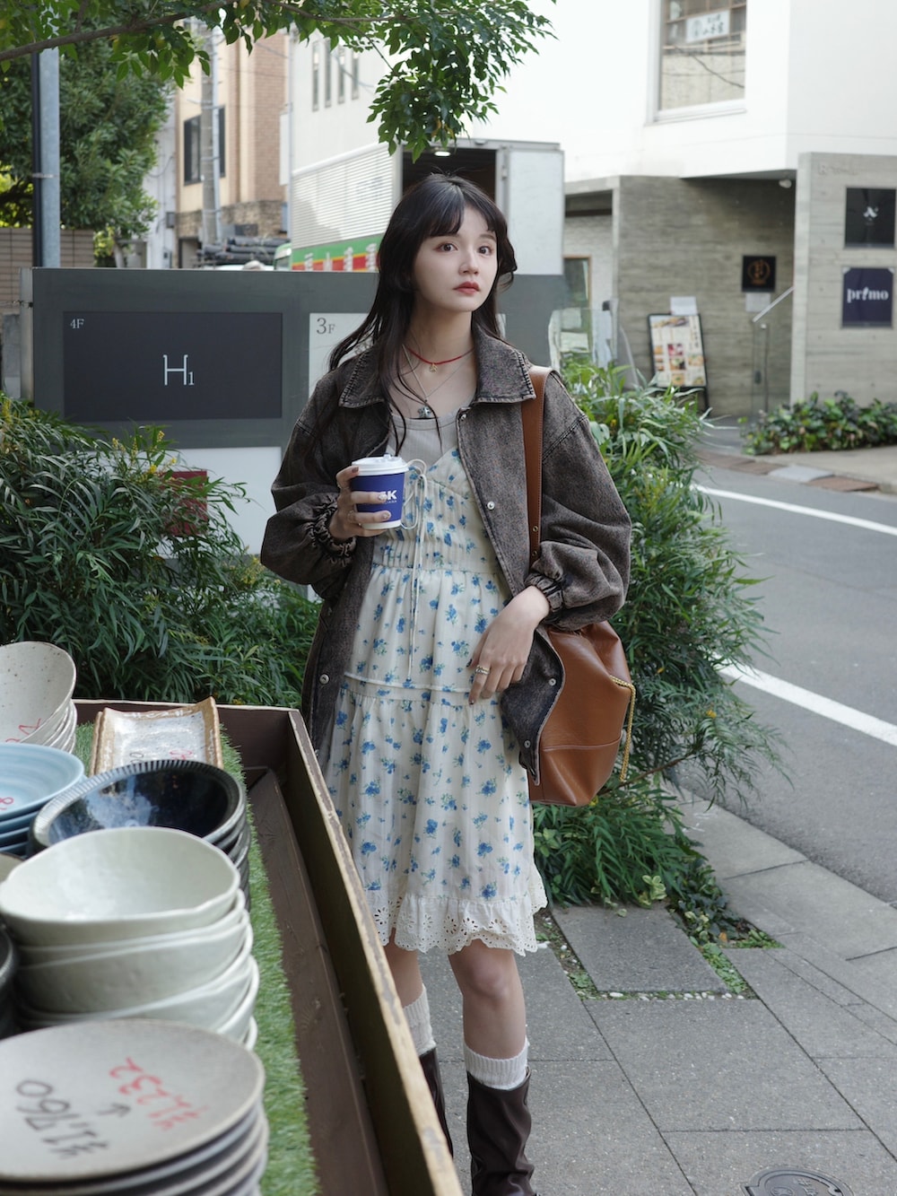 ブラウン系のデニムジャケット、ブラウン系のショルダーバッグ、ホワイト系のワンピースを着用したレディースの冬コーディネートの3枚目の写真