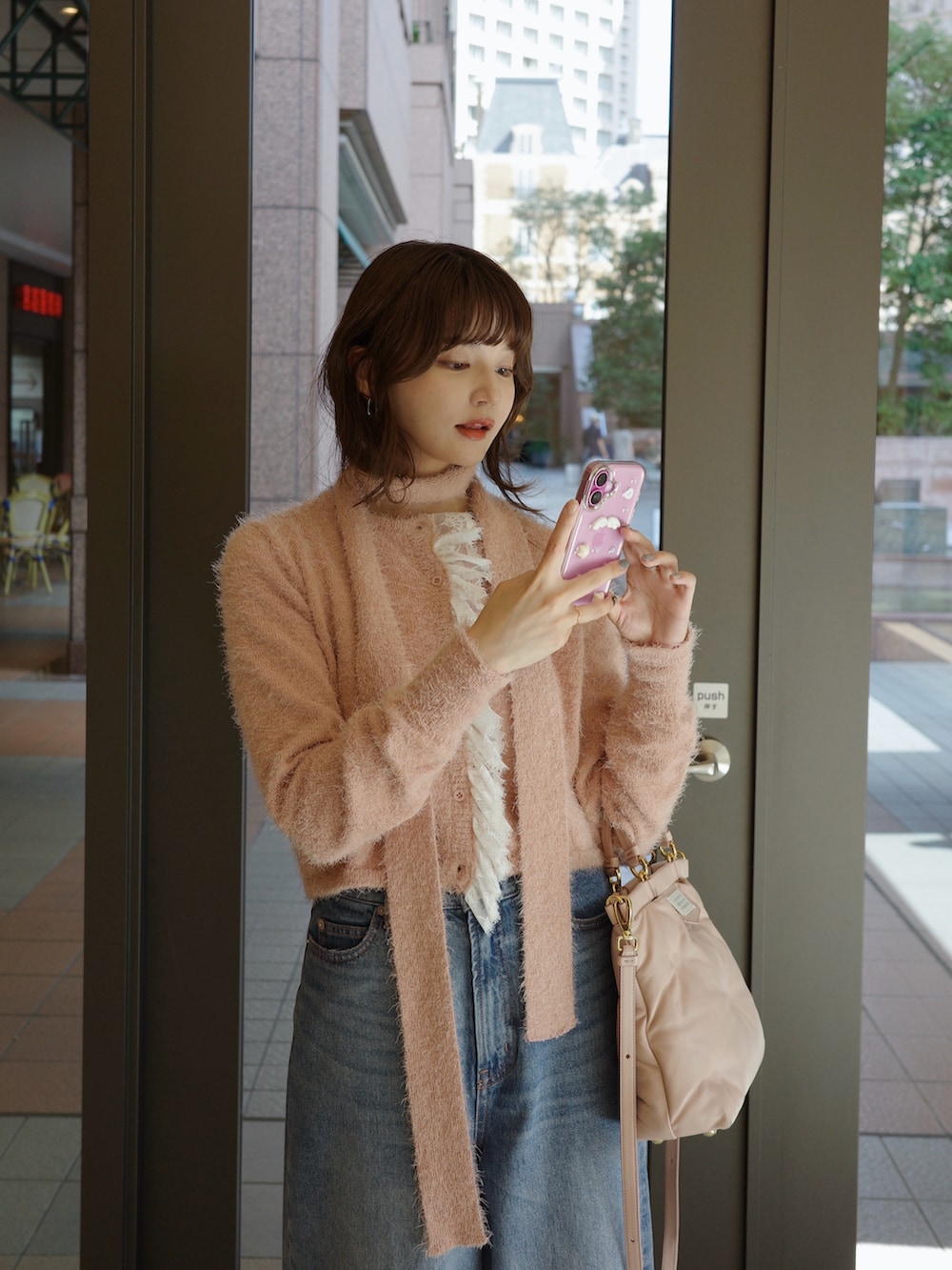 ピンク系のカーディガン/ボレロ、ブラック系のパンプスを着用したレディースの秋コーディネートの2枚目の写真