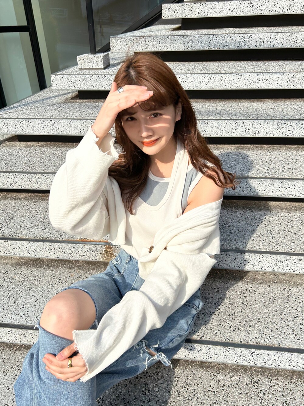 ホワイト系のタンクトップ、ブルー系のデニムパンツ、ホワイト系のサンダルを着用したレディースの春コーディネートの3枚目の写真