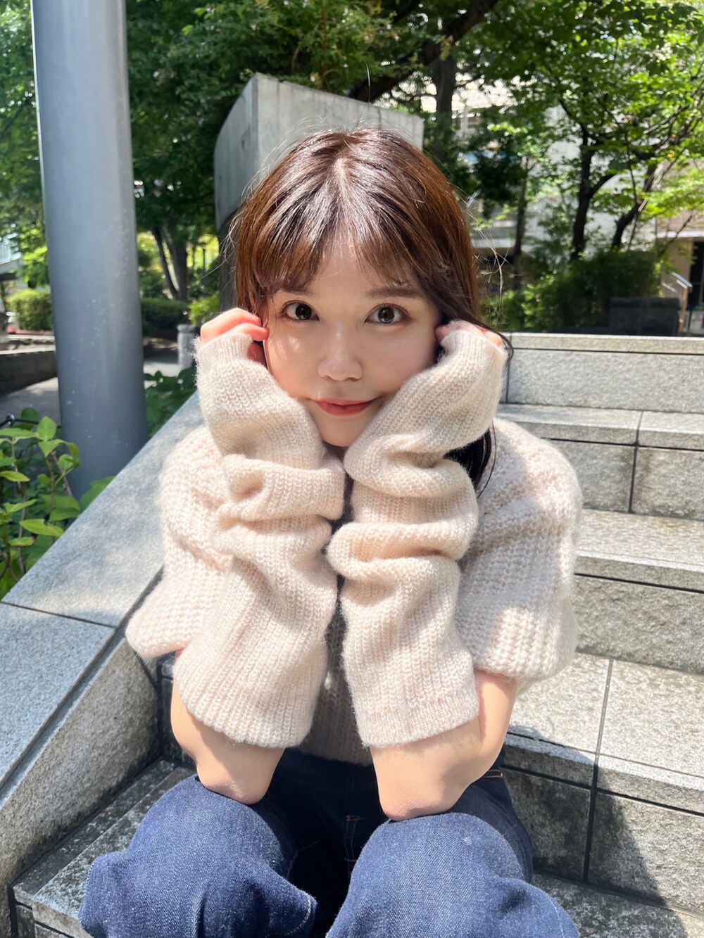 ホワイト系のニット/セーター、ブラック系のデニムパンツを着用したレディースの夏コーディネートの2枚目の写真