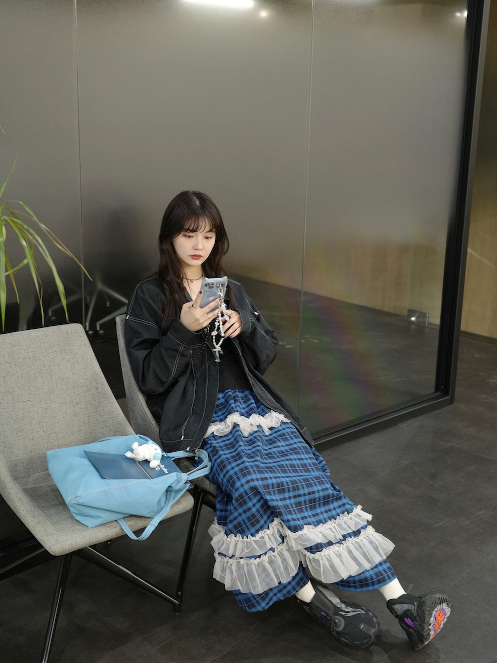 ブルー系のスカート、ブラック系のジャケット/アウターを着用したレディースの秋コーディネートの2枚目の写真