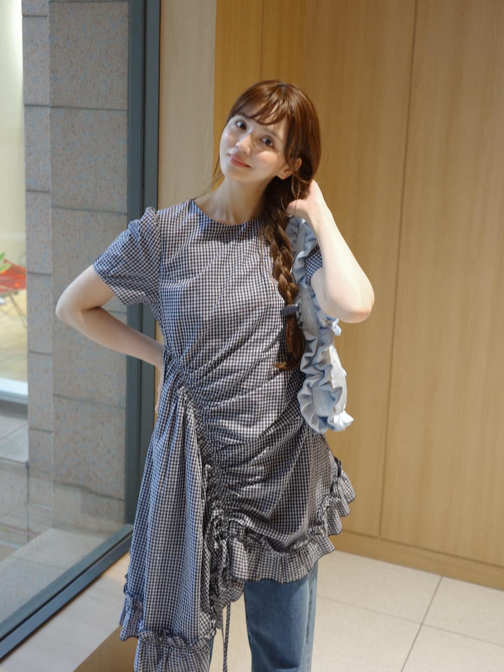 ブルー系のデニムパンツ、ブルー系のワンピース、ブルー系のハンドバッグを着用したレディースの春コーディネートの2枚目の写真