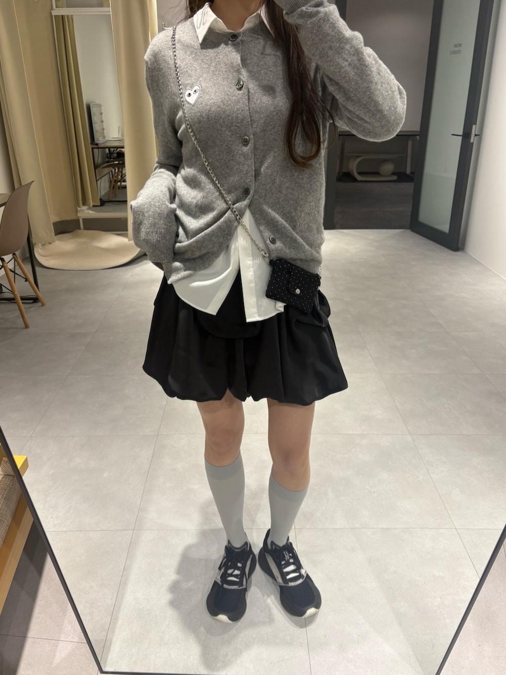 ブラック系のスカート、グレー系のカーディガン/ボレロを着用したレディースの春コーディネートの3枚目の写真