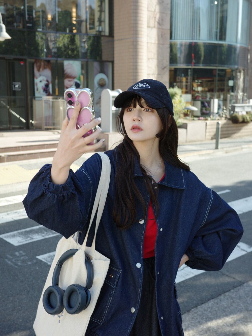 ブルー系のデニムスカート、ブルー系のデニムジャケット、ブラック系のブーツを着用したレディースの冬コーディネートの3枚目の写真