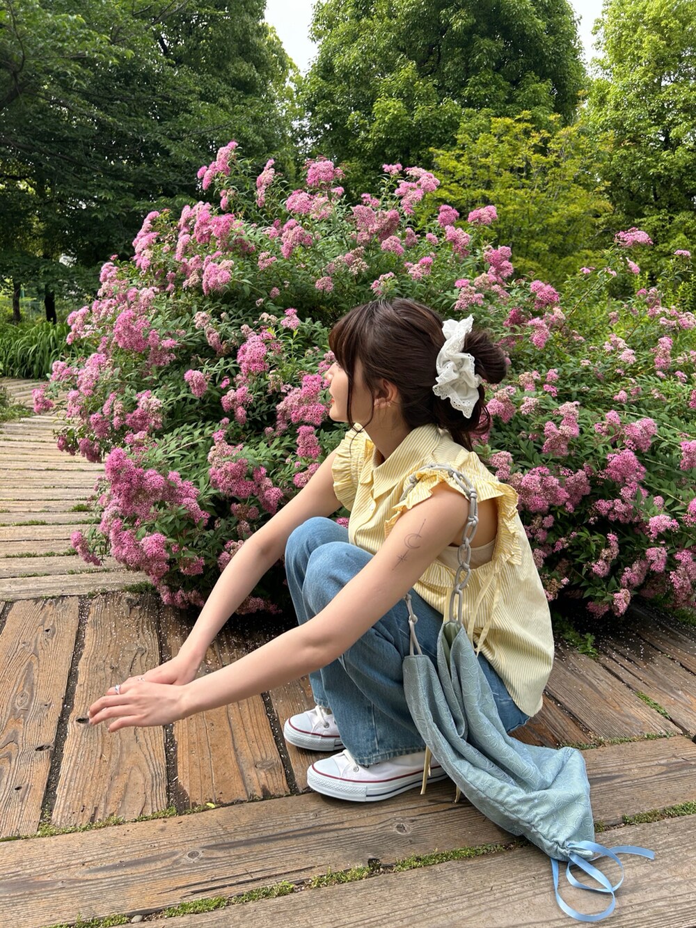 イエロー系のシャツ/ブラウス、ブルー系のデニムパンツを着用したレディースの夏コーディネートの2枚目の写真