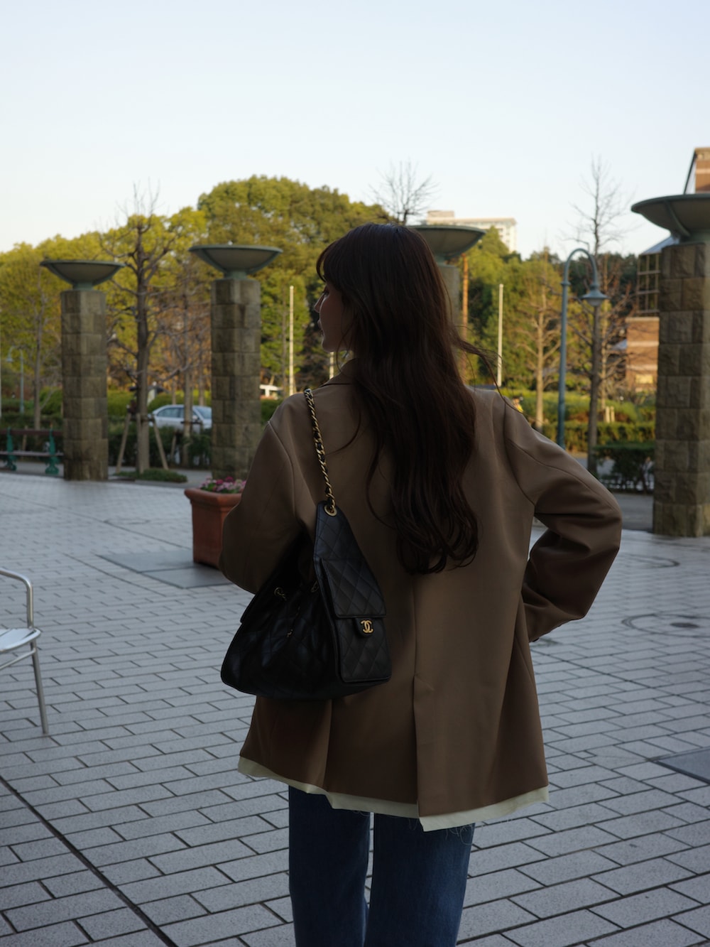 グレー系のテーラードジャケット、ホワイト系のシャツ/ブラウス、ブルー系のデニムパンツを着用したレディースの冬コーディネートの3枚目の写真