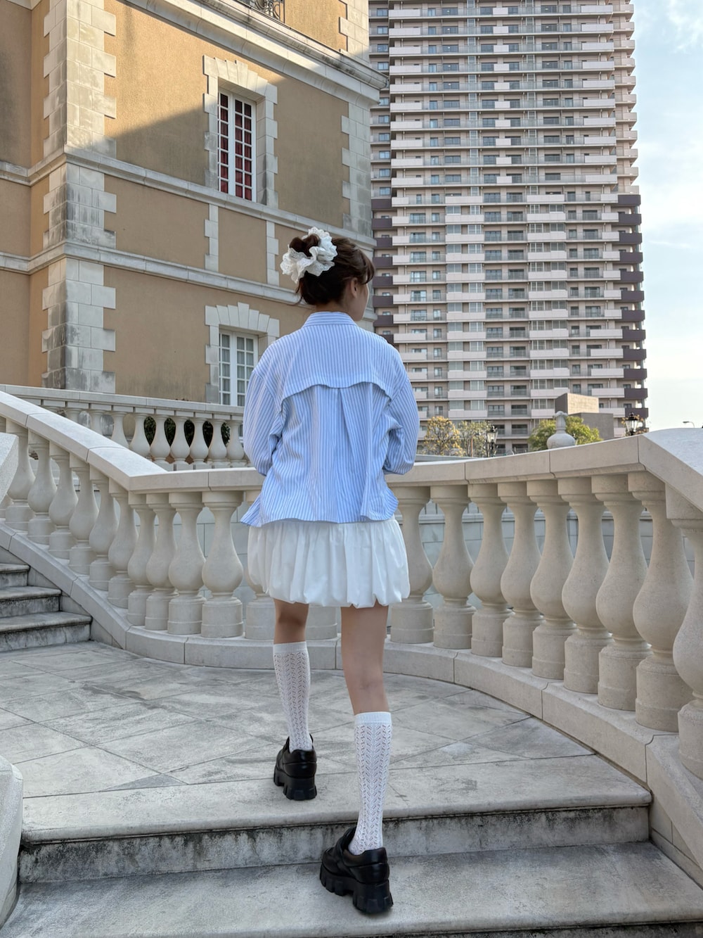 グレー系のキャミソール、ブルー系のシャツ/ブラウス、ホワイト系のスカートを着用したレディースの春コーディネートの2枚目の写真