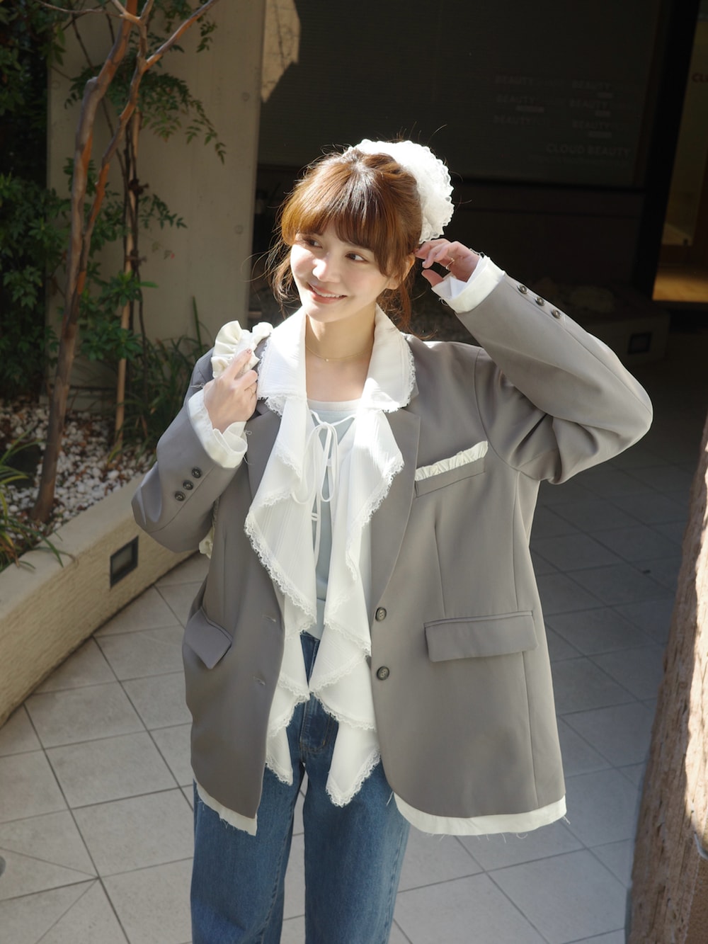 ホワイト系のシャツ/ブラウス、グレー系のテーラードジャケット、ブルー系のデニムパンツを着用したレディースの春コーディネートの2枚目の写真