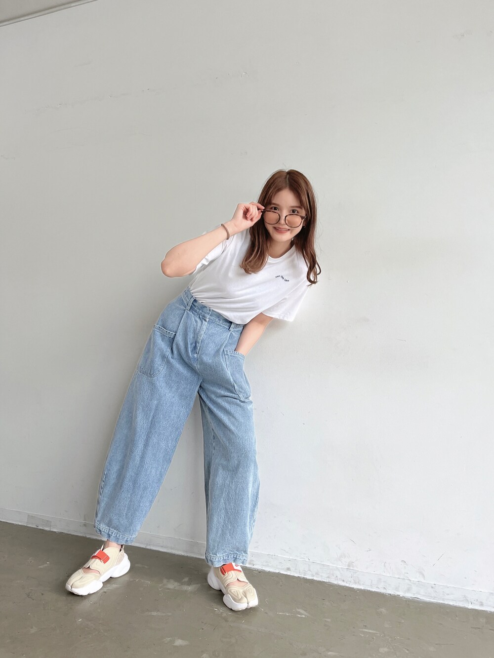 ブラック系のその他パンツ、ホワイト系のTシャツ/カットソー、ベージュ系のサンダルを着用したレディースの春コーディネートの4枚目の写真