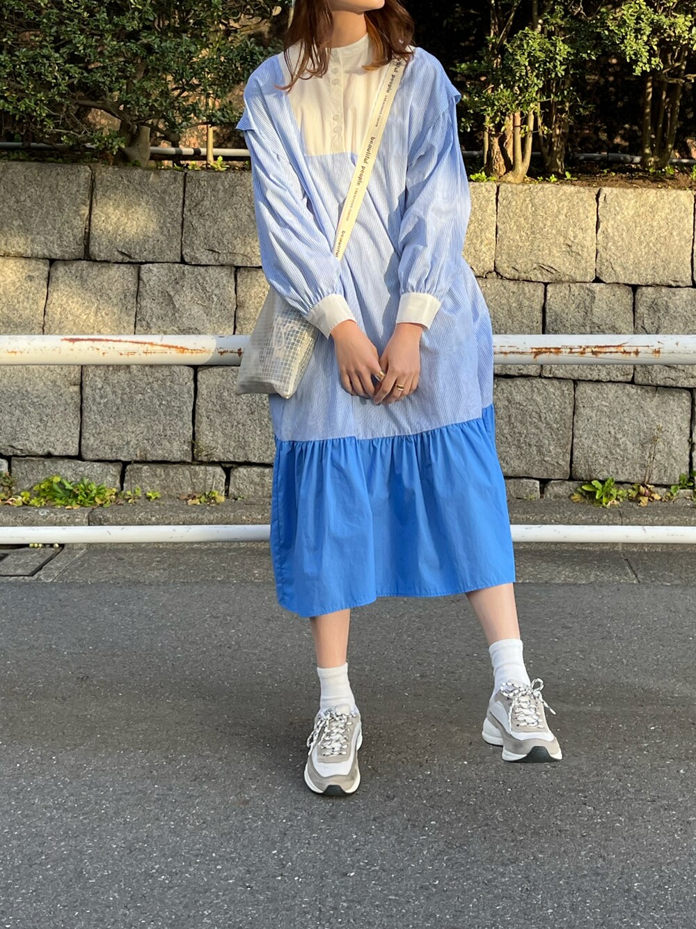 ブルー系のワンピース、その他のショルダーバッグ、ホワイト系のスニーカーを着用したレディースの春コーディネートの3枚目の写真