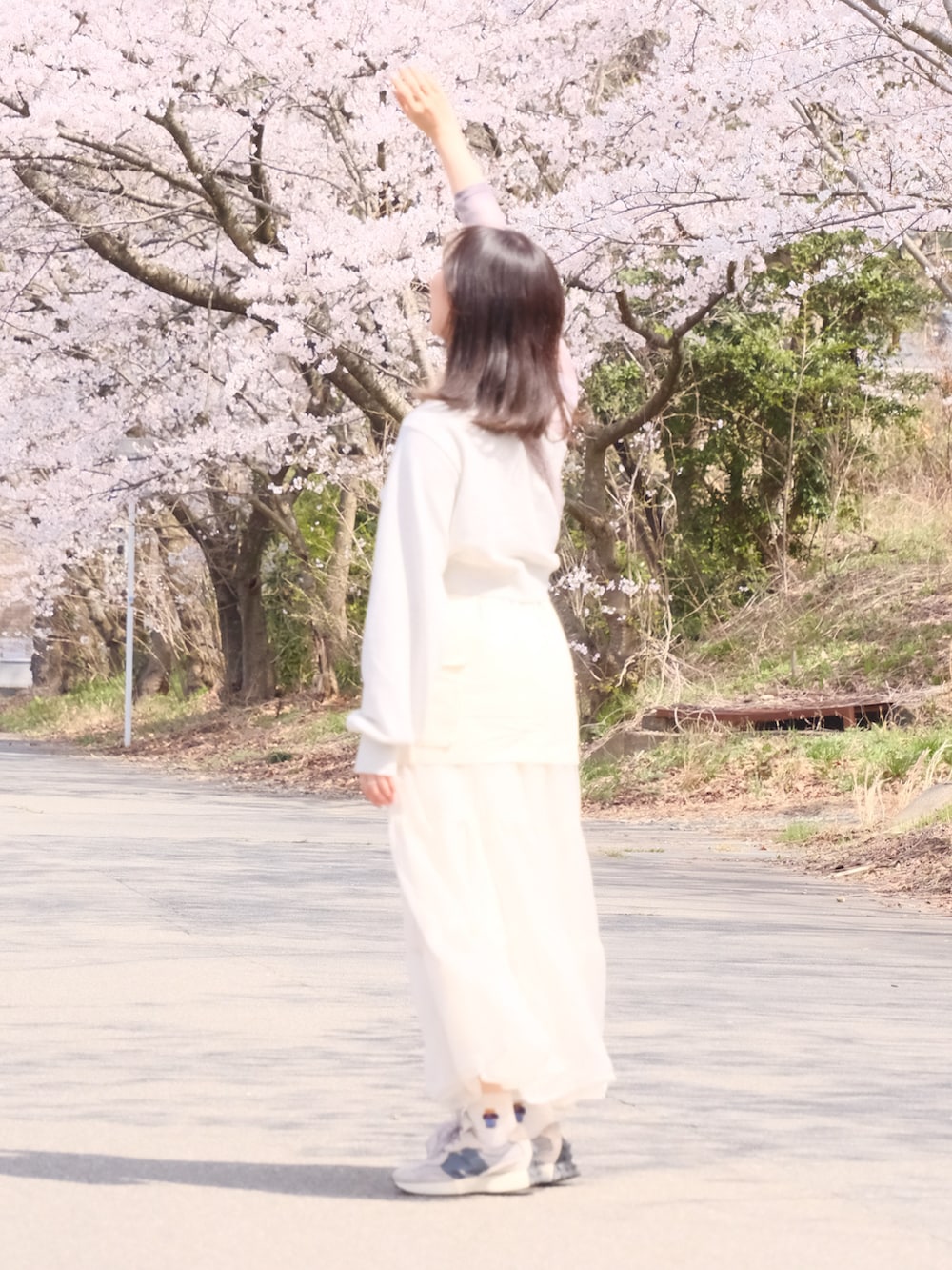 ホワイト系のスカート、ホワイト系のスウェット、グレー系のスニーカーを着用したレディースの春コーディネートの2枚目の写真