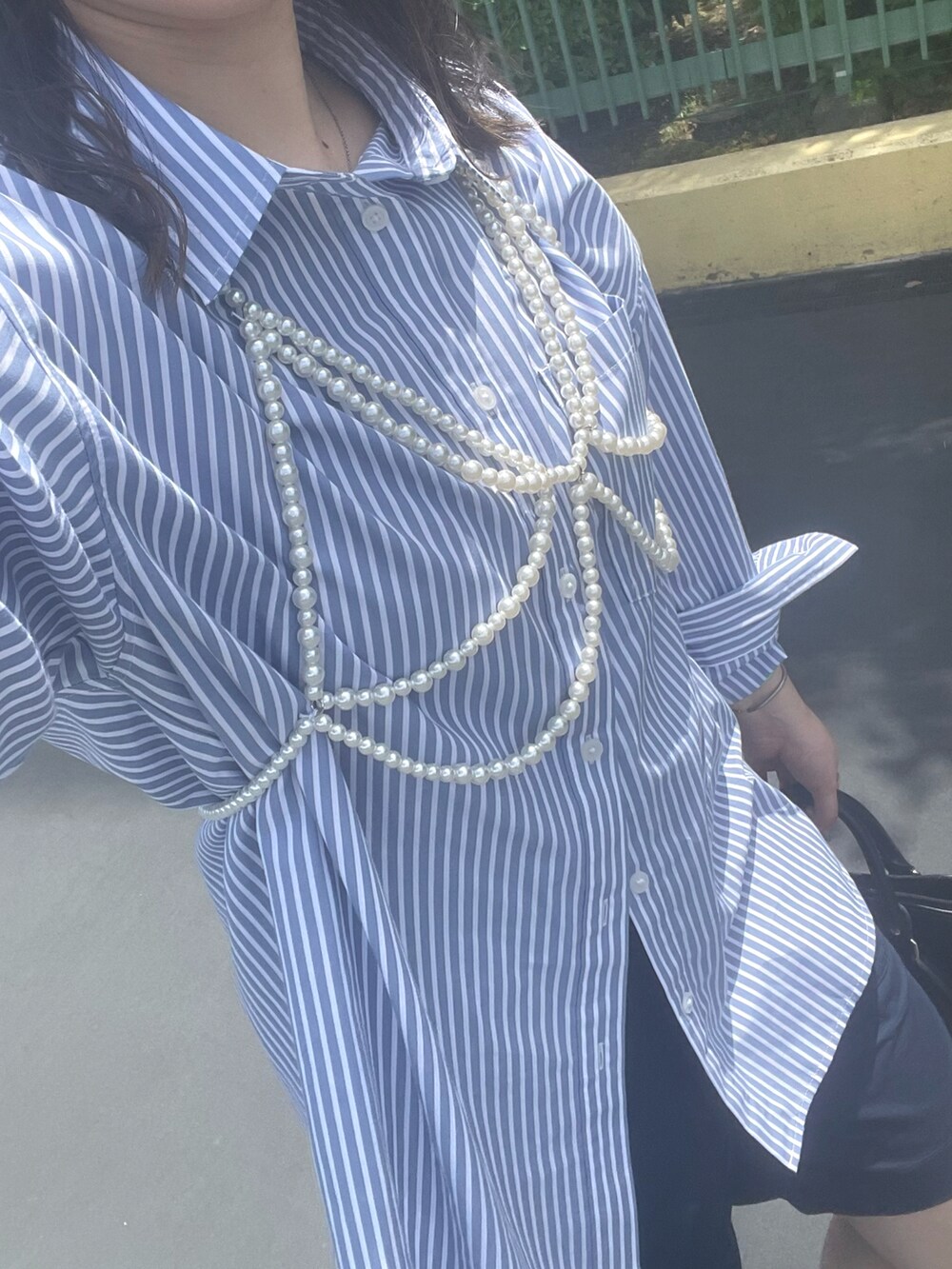 ブルー系のシャツ/ブラウス、ブルー系のパンツ、ブラック系のボストンバッグを着用したレディースの春コーディネートの2枚目の写真