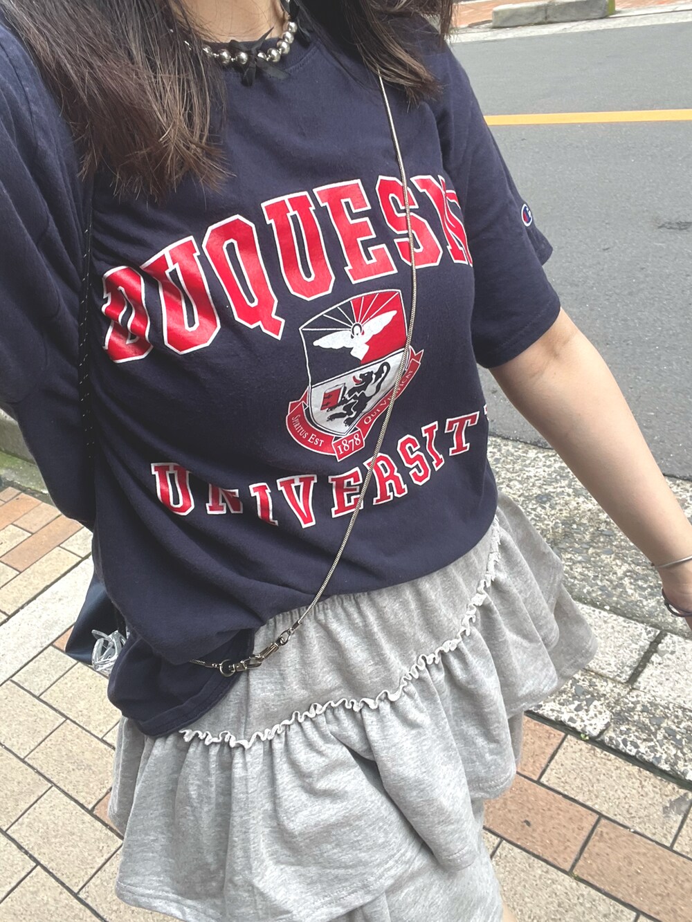 ブルー系のTシャツ/カットソー、グレー系のスカート、グレー系のスニーカーを着用したレディースの夏コーディネートの2枚目の写真