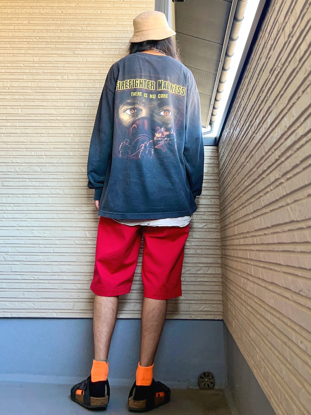 ブラック系のTシャツ/カットソー、レッド系のチノパンツ、ブラック系のシューズを着用したメンズの秋コーディネートの3枚目の写真