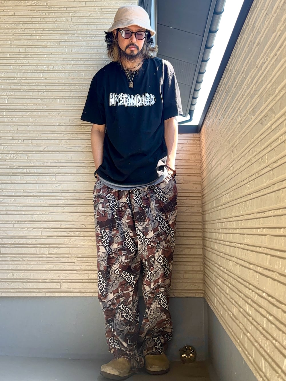 ブラック系のTシャツ/カットソー、ブラウン系のその他パンツ、グリーン系のシューズを着用したメンズの春コーディネートの3枚目の写真