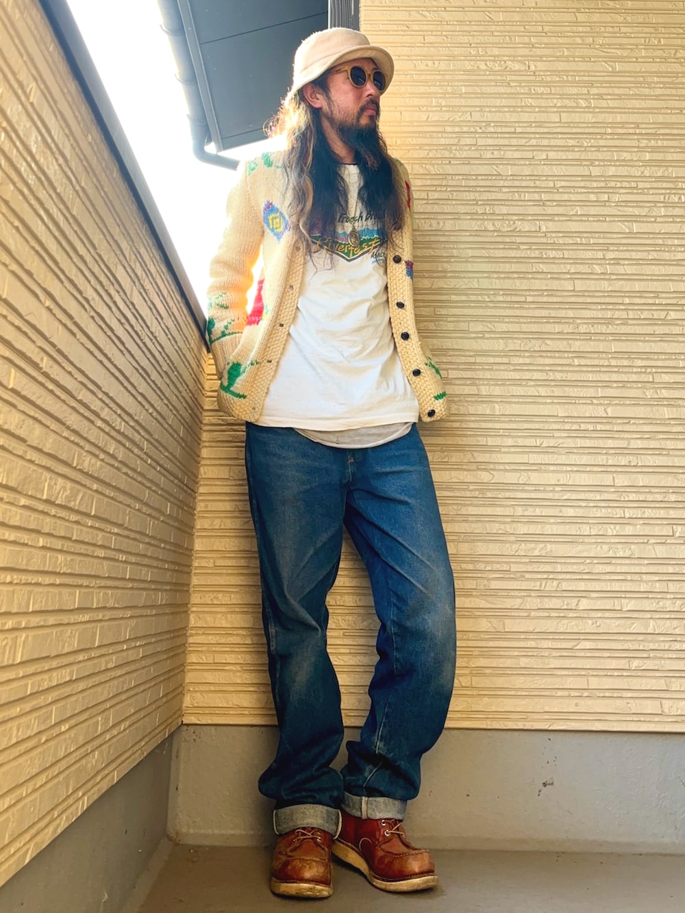 ベージュ系のカーディガン/ボレロ、ホワイト系のTシャツ/カットソー、ブルー系のデニムパンツを着用したメンズの冬コーディネートの4枚目の写真