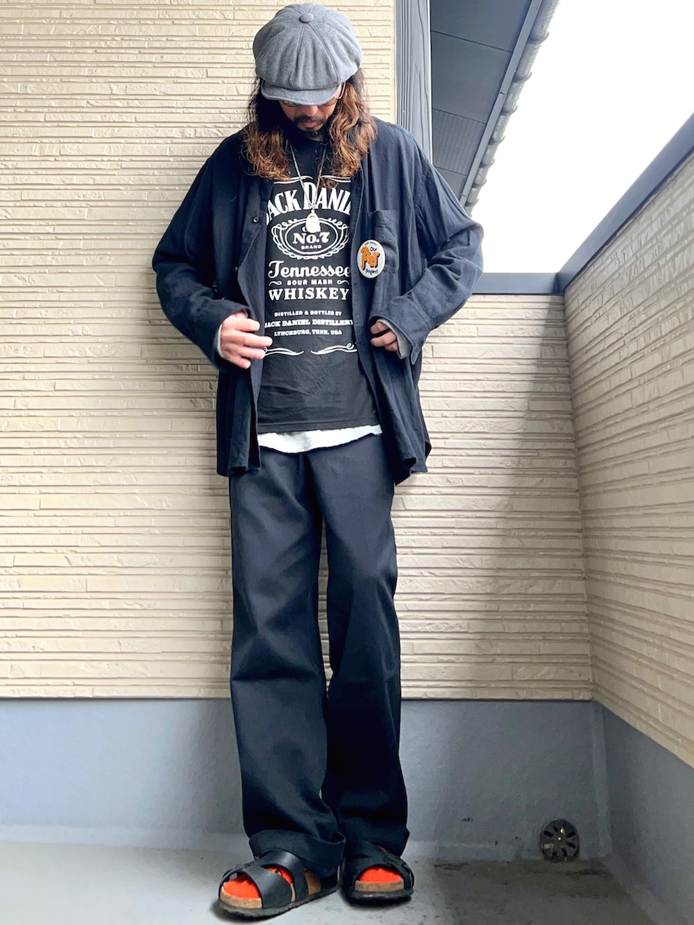 ブラック系のTシャツ/カットソー、ブラック系のチノパンツ、ブラック系のシューズを着用したメンズの春コーディネートの2枚目の写真