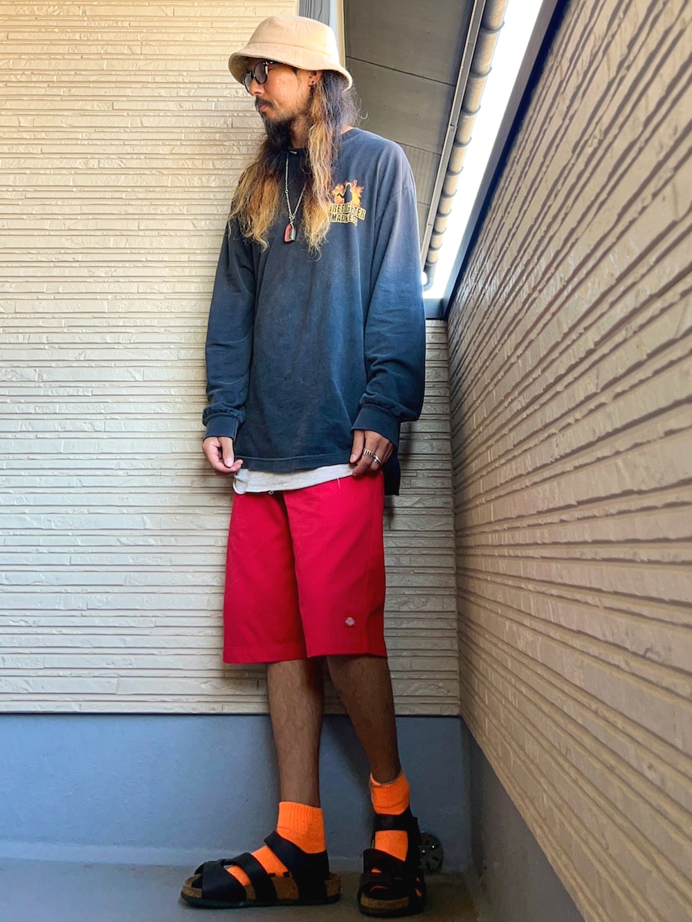 ブラック系のTシャツ/カットソー、レッド系のチノパンツ、ブラック系のシューズを着用したメンズの秋コーディネートの2枚目の写真