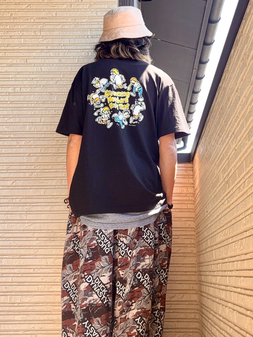 ブラック系のTシャツ/カットソー、ブラウン系のその他パンツ、グリーン系のシューズを着用したメンズの春コーディネートの4枚目の写真