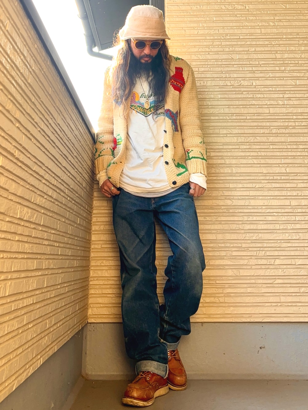 ベージュ系のカーディガン/ボレロ、ホワイト系のTシャツ/カットソー、ブルー系のデニムパンツを着用したメンズの冬コーディネートの2枚目の写真